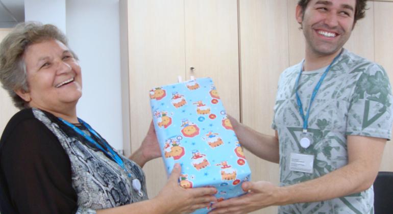 Campanha Papai Noel dos Correios mobiliza servidores de setores diversos da Prefeitura Municipal de Belo Horizonte. Foto: Divulgação PBH Dois servidores da Prefeitura com presente nas mãos.