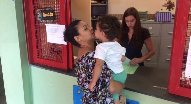 Próximo ano letivo começa com cerca de 10 mil novas vagas na educação infantil da Rede Municipal da capital mineira. Foto: Divulgação PBH Mãe com filho no colo faz inscrição em escola infantil da Rede Municipal de Ensino.