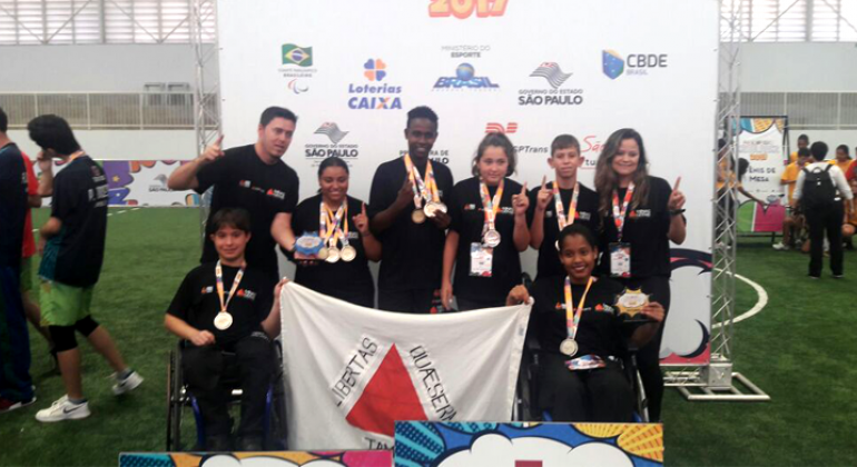 Atletas do programa Superar sendo fotografados com as medalhas adquirida durante os jogos. 