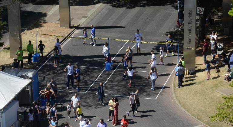 BH é da Gente terá atividades esportivas e recreativas Quadra de volei montada com fitas no chão na Praça da Savassi. Dois times jogam na quadra.