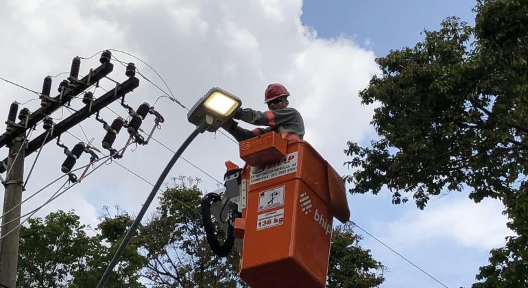 Operador instala lâmpada de nova tecnologia em poste no Barreiro