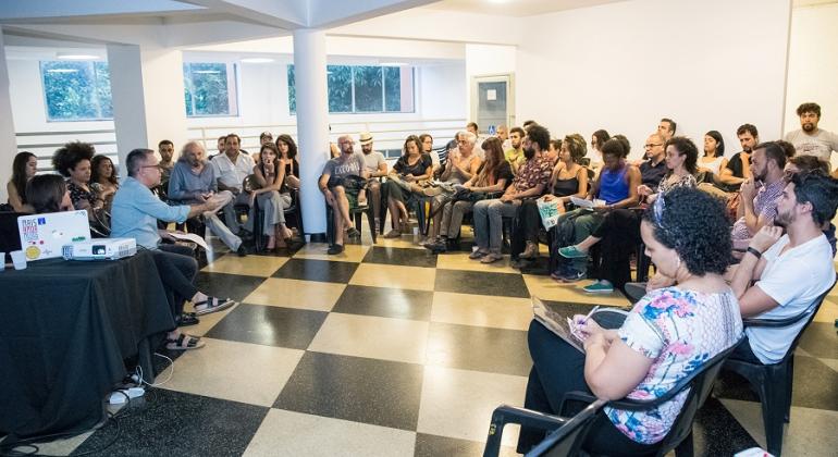 Mais trinta pessoas em reunião em uma sala.