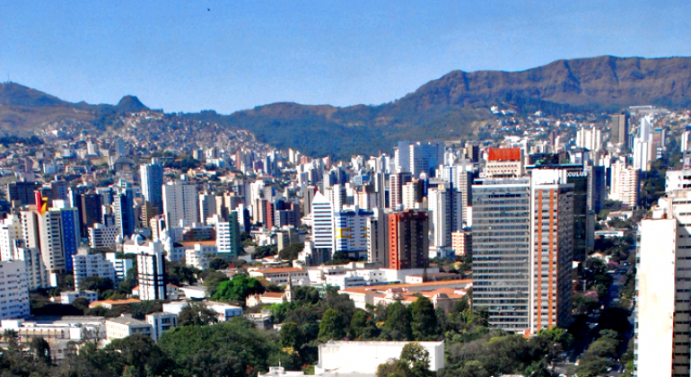 Prefeitura sedia encontro de secretários de Segurança e comandantes de guardas municipais de cerca de 30 cidades mineiras. Foto: Divino Advíncula/PBH Cidade de Belo Horizonte, com muitos prédios e céu azul, durante o dia. Ao fundo, Serra do Curral.