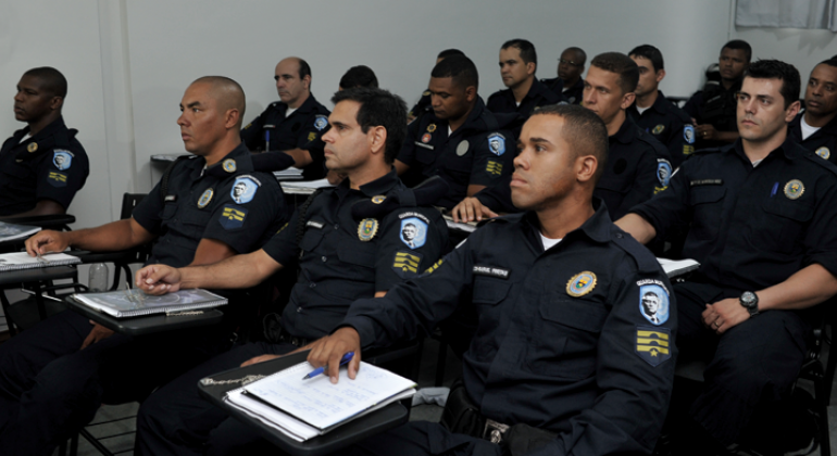 Prefeitura promove capacitação para a Guarda Municipal de Belo Horizonte sobre direitos e cidadania na terça-feira, dia 30 de janeiro. Foto: Tomás Cintra Mais de doze guardas municipais sentados em carteiras, fazendo curso de capacitação.