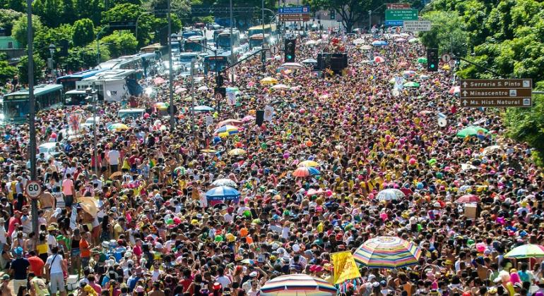 Mais de trezentos foliões lotal avenida com árvores e banheiros químicos nas laterais.