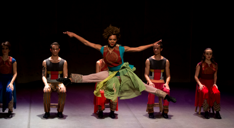 Dia 21/1 é a data final para as inscrições de projetos culturais para o Edital 2017/2018 da Lei Municipal de Incentivo à Cultura. Foto: Eugênio Sávio Mulher dá um pulo de dança em apresentação cênica, atrás, quatro pessoas estão sentadas.