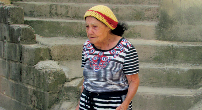 Senhora de idade caminha no Aglomerado da Serra.