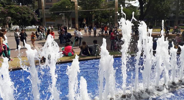 Fonte de água da Savassi à frente; ao fundo, pessoas passeiam ou descansam, sentadas.