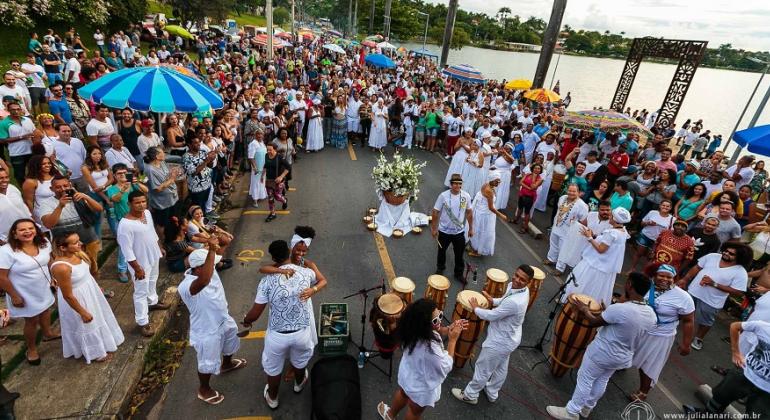 A manifestação, que tem apoio da Belotur, reverencia a pluralidade cultural os rituais de Candomblé e de Umbanda. Foto: Divulgação/PBH Mais de vinte pessoas vestidas de branco, do Candomblé, homenageiam Iemanjá na beira da Lagoa da Pampulha. Mais de cem pessoas assistem.