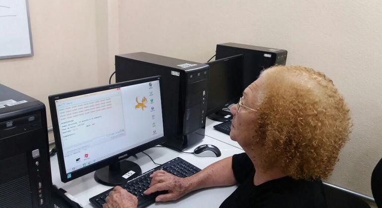 Através da Prodabel, Prefeitura oferece curso que ensina pessoas com até 80 anos a utilizar computadores. Foto: Divulgação PBH Idosa santada em frente ao computador, digitando
