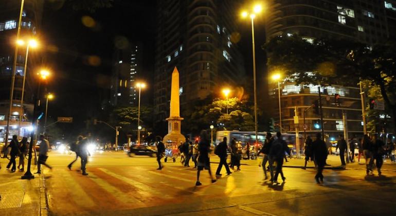 Fiscalização e prevenção atuam de forma conjunta em Belo Horizonte para proporcionar ambiente seguro à população. Foto: Adão de Souza/PBH Mais de vinte pessoas circulam na Praça Sete, durante a noite.