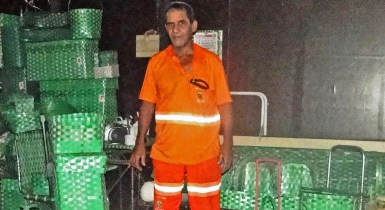 Plástico descartado é transformado em objetos para como cestas para pão e sofás por gari da SLU. Foto: Divulgação PBH Gari da SLU cercado de artesanatos de plástico que confecciona.