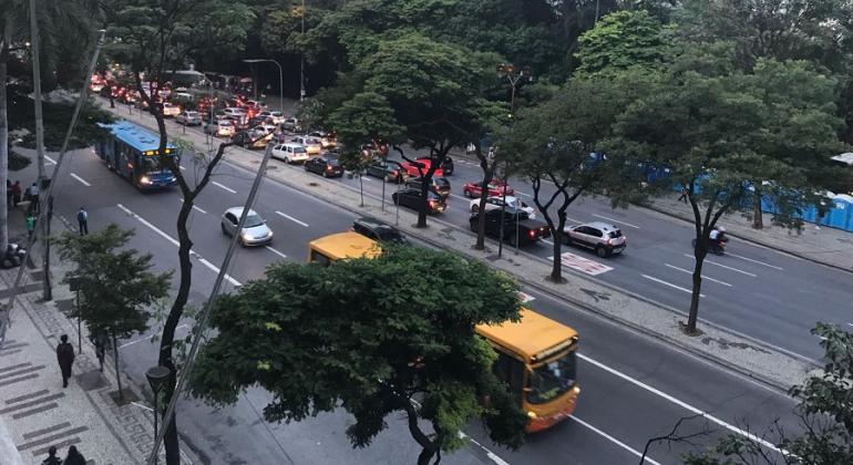 Carros e ônibus transitam na avenida Afonso Pena no início da noite.