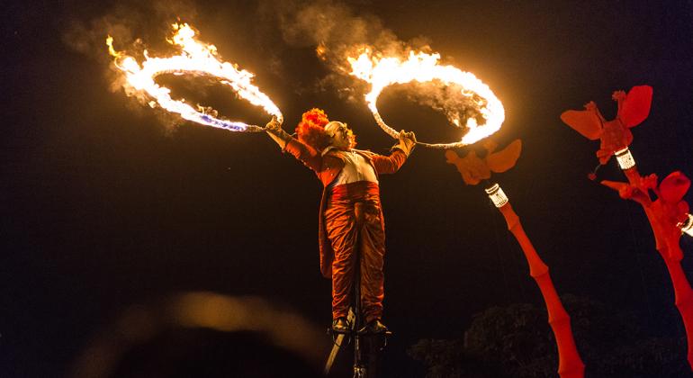 Espetáculo Les Girafes - FIT-BH 2016. Foto: Mariane Botelho Em um pedestal, ator segura dois arcos em chamas. Foto ilustrativa