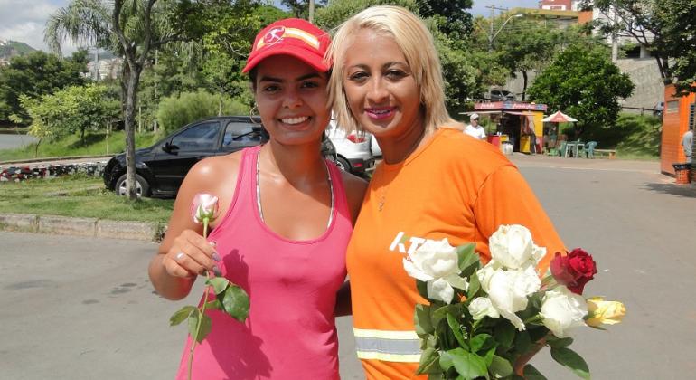 Gari abraça cidadã e lhe dá uma rosa em homenagem ao Dia Internacional da Mulher.