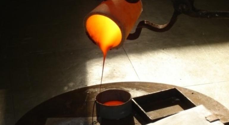Servidores da Secretaria Municipal de Meio Ambiente desenvolvem pesquisa para aproveitamento de resíduos na produção de vidros. Foto: Wanderson Marinho. Recipiente com vidro fundido na cor laranja e amarelo. Vidro produzido com resíduos de marmoria em pesquisa de servidores da Secretaria Municipal do Meio Ambiente