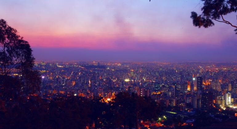 Vista de Belo Horizonte durante a noite com muitos prédios e luzes. 