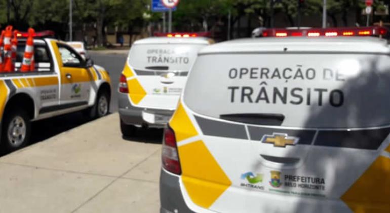 Três traseiras de carros da BHTrans com os seguintes dizeres em cada um deles: "Operação de trânsito".