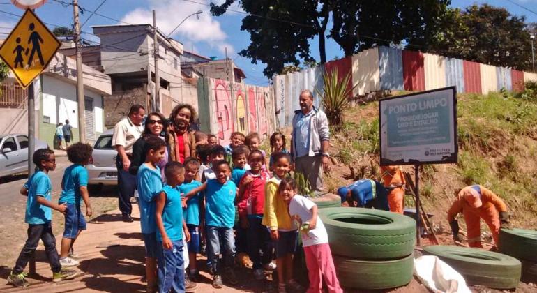 Implantação do Ponto Limpo na avenida Perimetral, com presença de cerca de 20 alunos da Escola Municipal Edith Pimenta da Veiga.