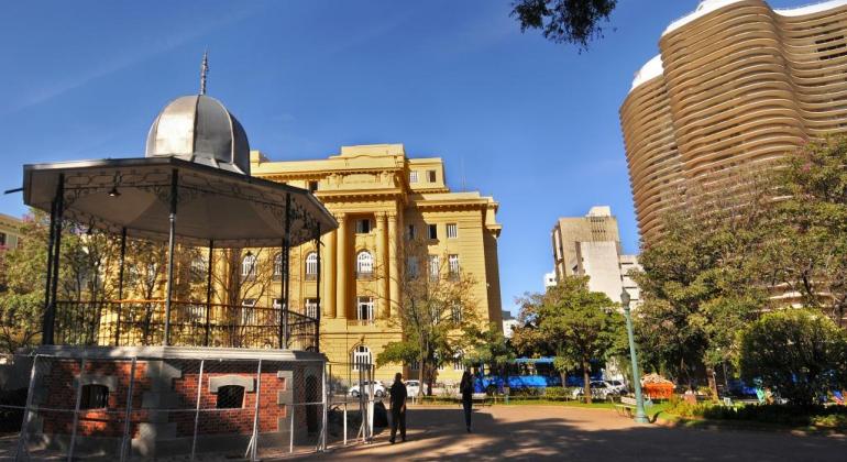 Coreto da Praça da Liberdade; ao fundo, dois prédios. 