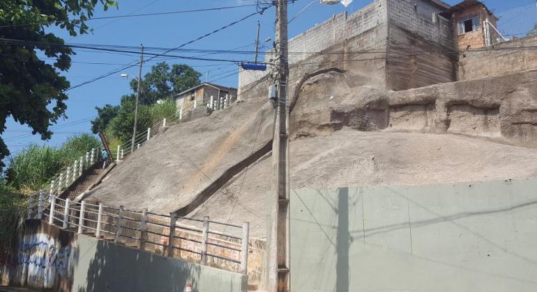 Obras de eliminação de risco em encostas levam mais segurança para os moradores Encosta com duas casas no topo. Há um posta na frente