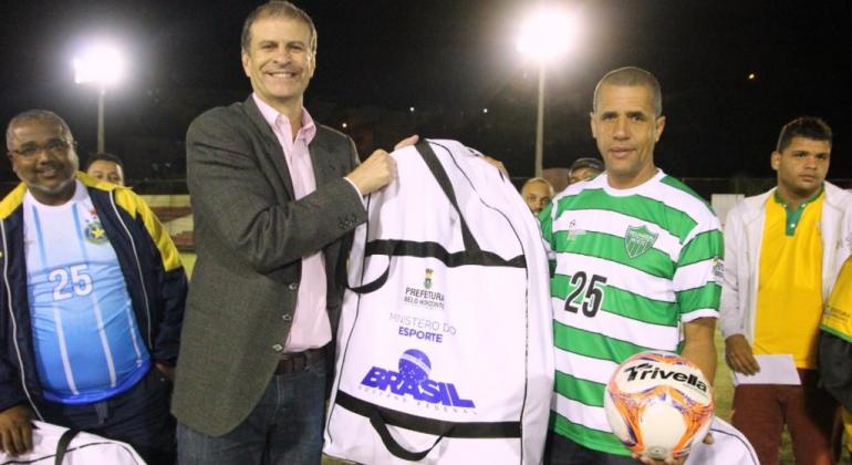 Distribuição de kit esportivo, foguetório e vitória do Inconfidência marcam a abertura da Copa dos Campeões de Futebol Amador de BH. Foto: Divulgação PBH Secretário municipal de Esportes e Lazer, Elberto Furtado, distribui kit esportivo na abertura da Copa dos Campeões.
