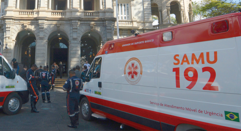 A Prefeitura informa que o Serviço de Atendimento Móvel de Urgência (SAMU) conta com novo prestador de serviços. Foto: Amira Hissa/PBH Cinco funcionários do SAMU ao lado de ambulância.