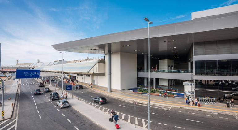 Vista parcial da fachada do Aeroporto Internacional Tancredo Neves, em Confins, durante o dia. 