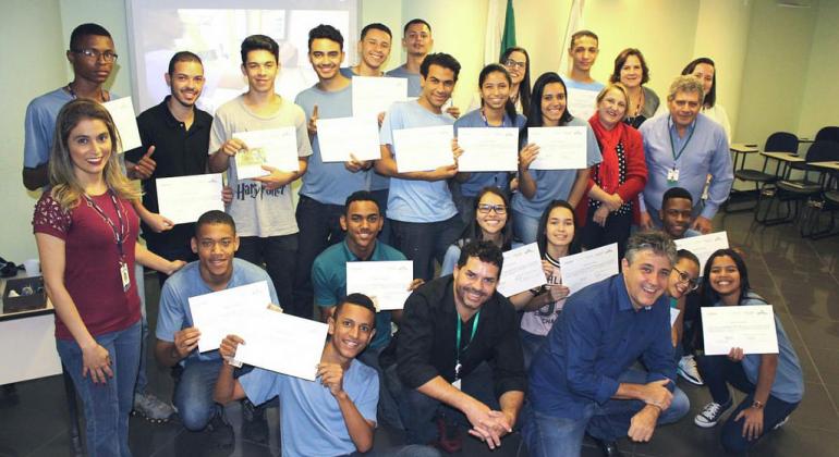 Instrutores e turma de jovens aprendizes exibindo certificados do curso da prodabel.