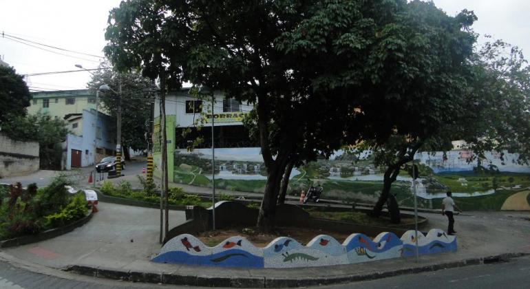 Uma essoa em praça com área verde e pinturas