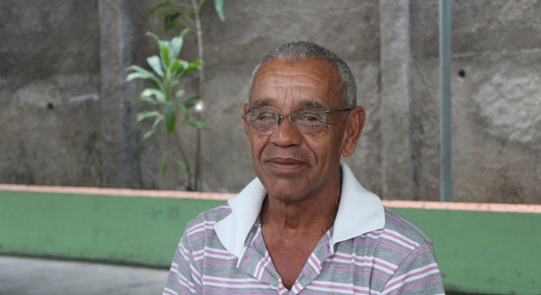 Pessoas em situação de vulnerabilidade têm mais segurança e apoio no Albergue Tia Branca. Foto: Divulgação PBH Senhor de óculos; ao fundo, um muro com uma planta.