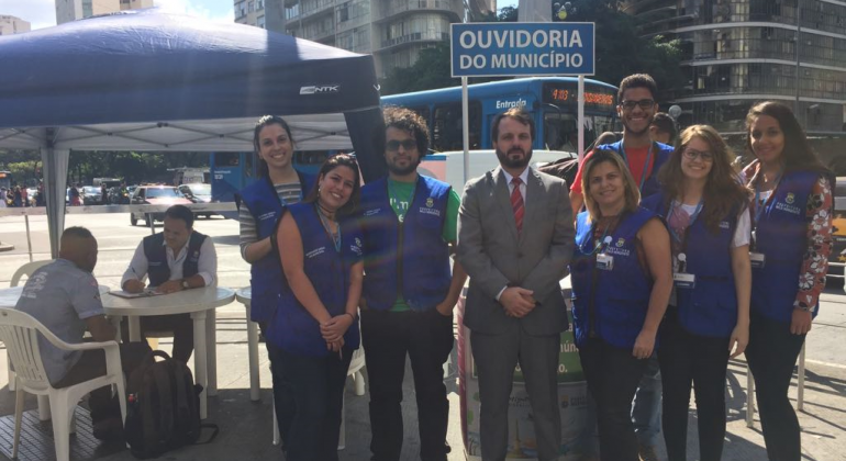 Equipe posa na Praça Sete com placa "Ouvidoria do Município"