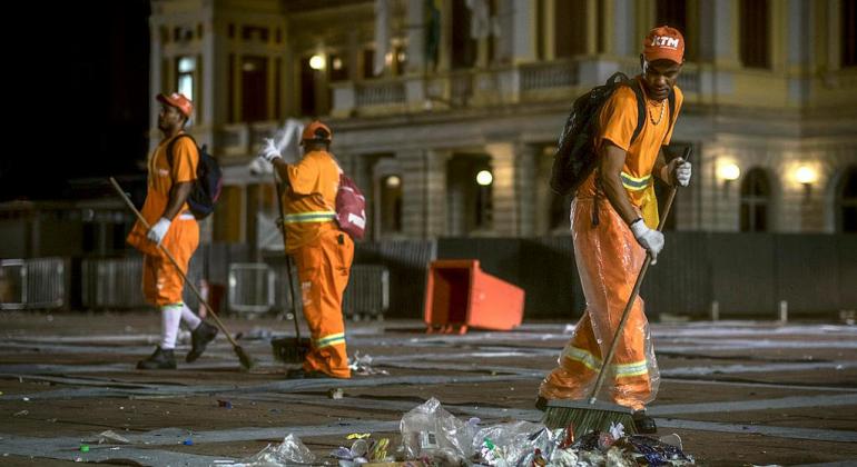 Equipes de limpeza promovem ações diárias no Hipercentro. Foto: Marcelo Santos/PBH Equipe de três garis realizando varrição na Praça da Estação.