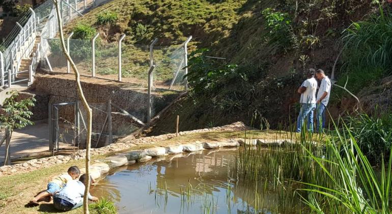 Crianças brincando na beira do lago que fica no parque