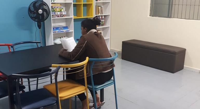 Unidade de Acolhimento Transitório abriga jovens em vulnerabilidade social. Foto: Divulgação/PBH Sala de leitura e mulher sentada lendo