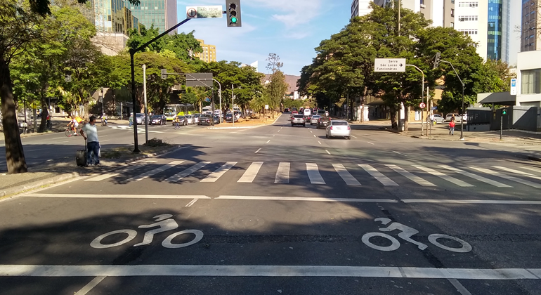 Rua vazia, de frente para faixa de pedestres e motocicletas pintadas no chão