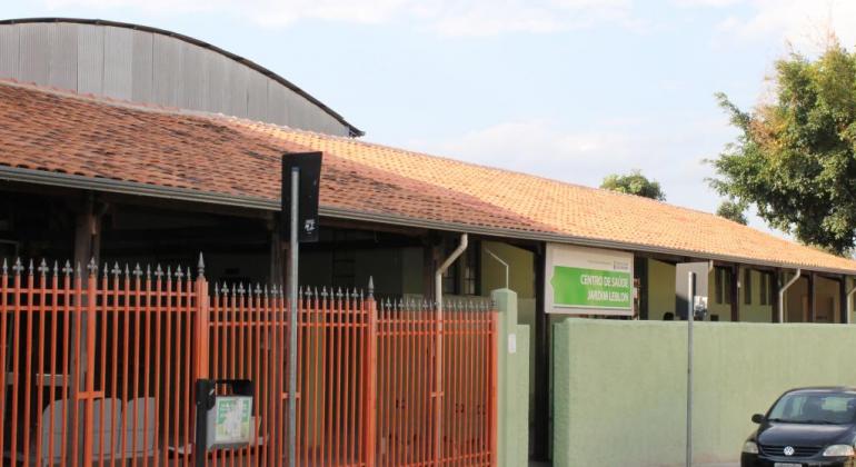 Fachada do Centro de Saúde Leblon, com portão laranja e paredes verdes
