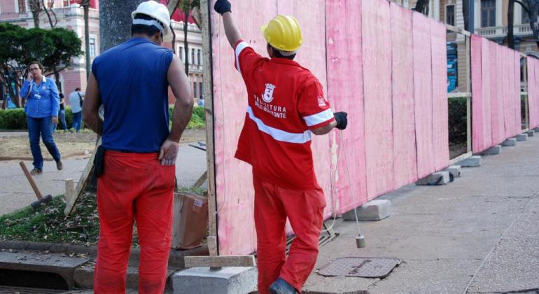 Ação cultural transforma da Praça da Liberdade em galeria de arte a céu aberto Operários da Secretaria de Obras colocam painéis na Praça da Liberdade