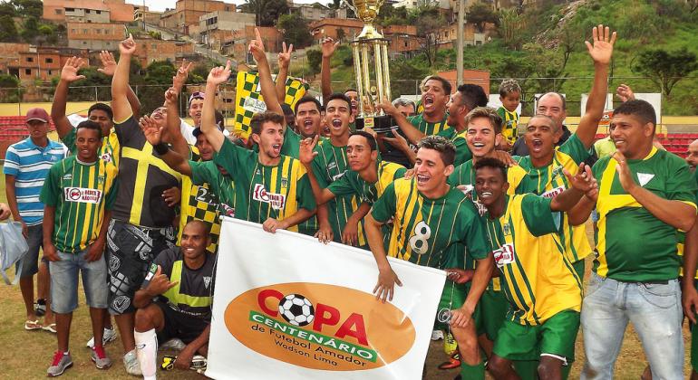 Time ganhador de futebol da copa centenário posa com a taça