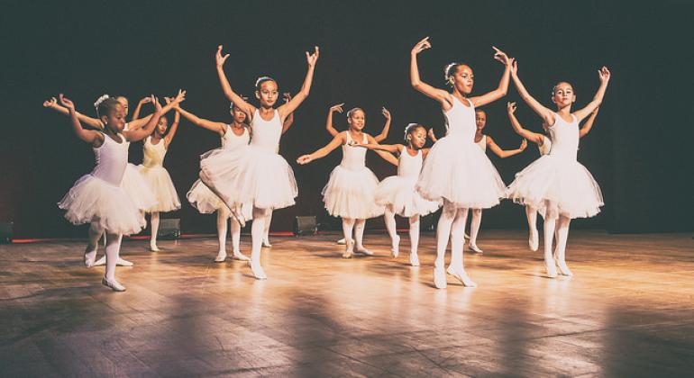 Inscrições para reuniões preparatórias da V Conferência Municipal de Cultura A foto mostra dez bailarinas usando colant e saia tu-tu brancos, em pose típica de bailarinas em um palco.