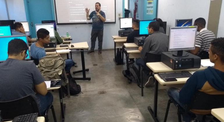 Prodabel promove curso de Robótica e insere os alunos em um mercado promissor. Foto: Divulgação/PBH Professor e cerca de dez alunos em laboratório de computadores