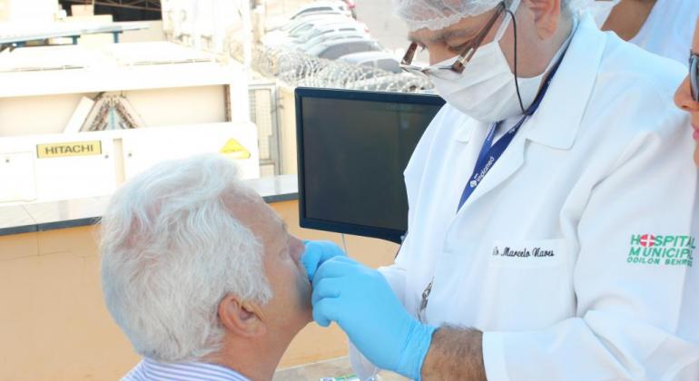 Dentista executa procedimento em paciente idoso.