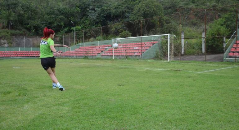 Mulher chuta bola ao gol