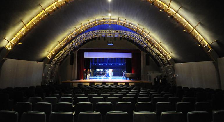 A foto mostra a plateia de um teatro. 