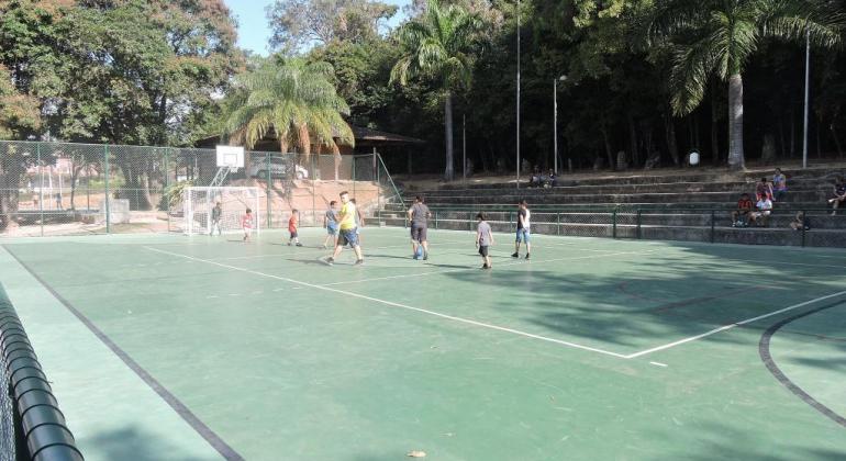 Quadro do parque lagoa do nado em dia de sol. Crianças jogam basquete