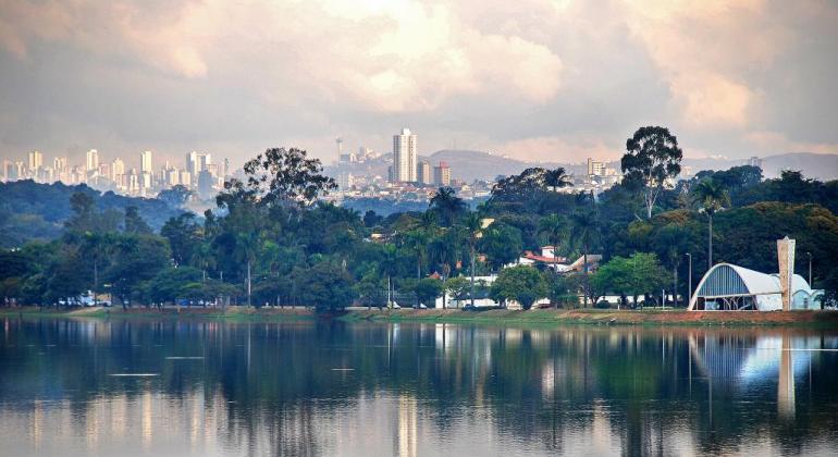 Lagoa da Pampulha com a igreja à direita e prédios ao fundo