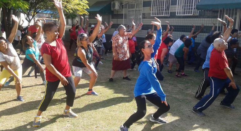 Idosos do bairro Tirol participam de atividades de saúde e interação social Idosas se exercitam ao ar livre