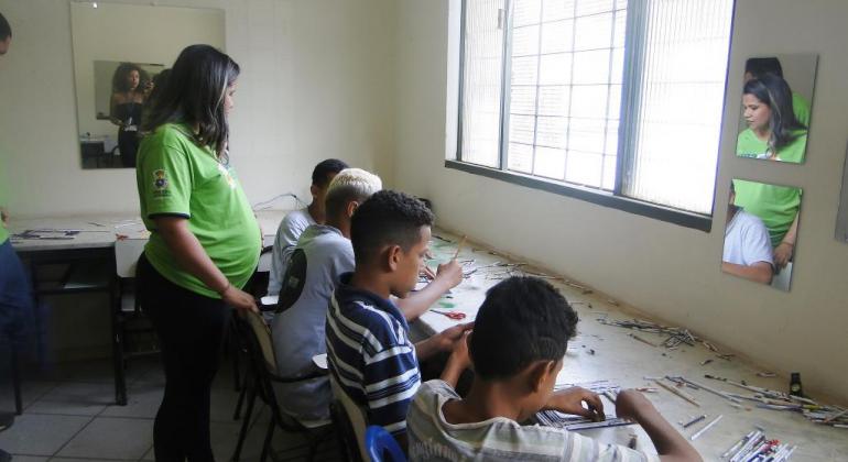 Quatro jovens e uma profissional do CRAS Taquaril fazendo artesanatos