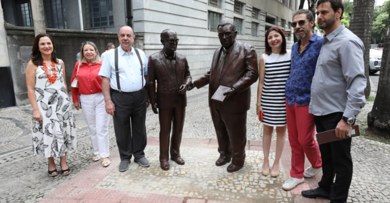 Pessoas ao redor da estátua de Carlos Drummond de Andrade e Pedro Nava.