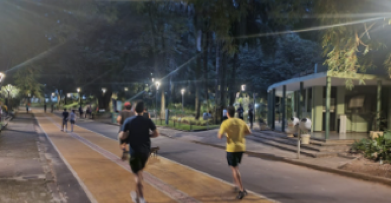 Dois homens correndo à noite no parque
